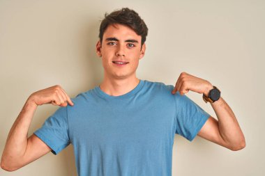 Teenager boy wearing casual t-shirt standing over isolated background looking confident with smile on face, pointing oneself with fingers proud and happy.