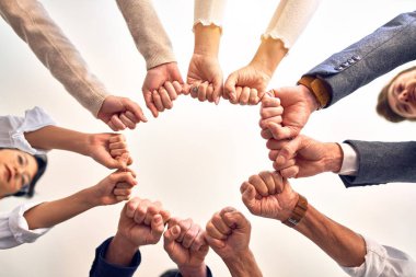 Bir grup işçi ofiste yumruk tokuşturuyor.