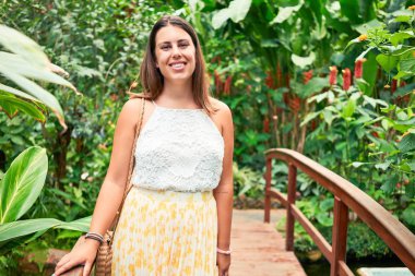 Güneşli bir yaz gününde, kelebek bahçesinde mutlu ve neşeli gülümseyen güzel bir kadın.