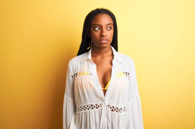 Güzel Afro-Amerikalı kız bikini ve yaz elbisesi giyip gülümsüyor.