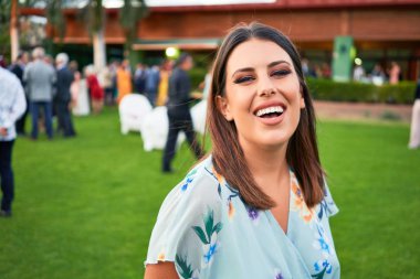 Genç, güzel ve zarif bir kadın. Gelinliği ile mutlu ve neşeli gülümsüyor.