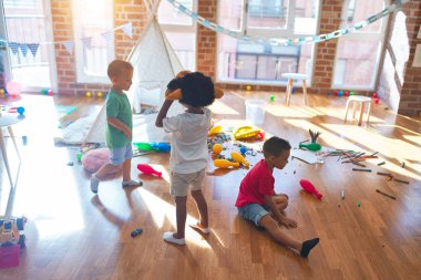 Anaokulunda bir sürü oyuncakla oynayan sevimli çocuklar.