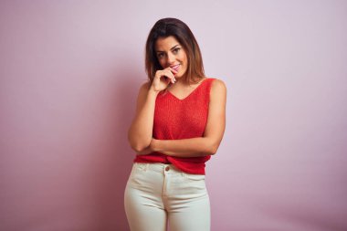 Turuncu t-shirt giyen ayakta genç güzel İspanyol kadın