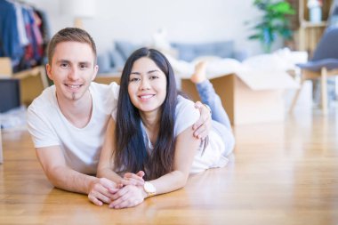 Genç güzel çift karton kutular etrafında yeni evde yatarken