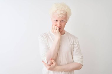 Genç albino sarışın adam, sıradan bir tişört giyiyor. İzole edilmiş beyaz arka plan üzerinde duruyor. Kollarını kavuşturup depresyondan sıkılmış ve yorgun görünüyor..