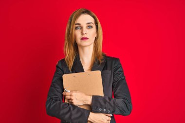 Genç güzel kızıl başlı iş kadını takım elbise tutarak flip board giyiyor