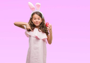 Esmer Latin kız Paskalya tavşan kulakları kendisine sürpriz yüz işaret parmağı ile giyiyor