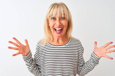 Orta yaşlı bir kadın, donanma çizgili tişört giyip izole edilmiş beyaz arka plan üzerinde durmuş çılgın ve başarıyı kutlarken kollarını kaldırmış ve gözleri açık bir şekilde heyecanlı bir şekilde çığlık atıyordu. Kazanan konsept