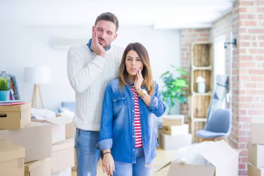 Genç ve güzel bir çift, diş ağrısı ya da diş ağrısı yüzünden yeni evlerinde karton kutuların etrafında durup ağızlarına acı dolu bir ifadeyle dokunuyor. Dişçi konsepti.