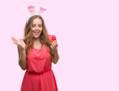 Sarışın genç kadın giyiyor Paskalya tavşanı çok mutlu ve heyecanlı, kazanan ifade büyük gülümseme ile çığlık zaferini kutluyor kulaklar ve ellerini kaldırdı