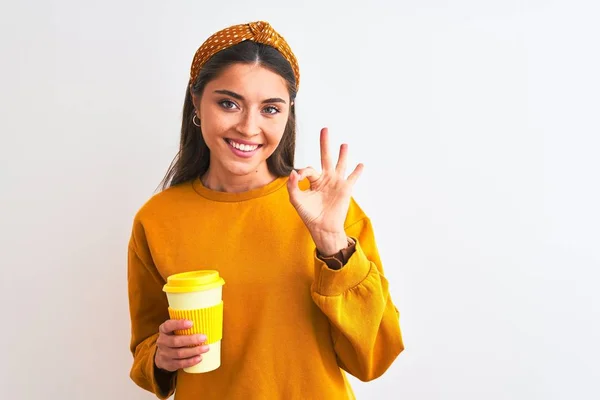 年轻美丽的女人喝着一杯咖啡 隔着孤独的白底 手拿着手签 是极好的象征 — 图库照片