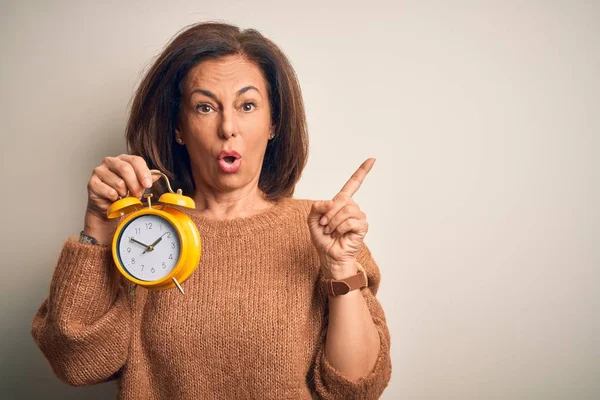 Brünette Frau Mittleren Alters Mit Klassischem Wecker Über Isoliertem Hintergrund — Stockfoto