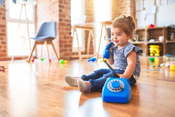 Güzel Çocuk Anaokulunda Yerde Oturmuş Antika Bir Telefonla Oynuyor — Stok fotoğraf