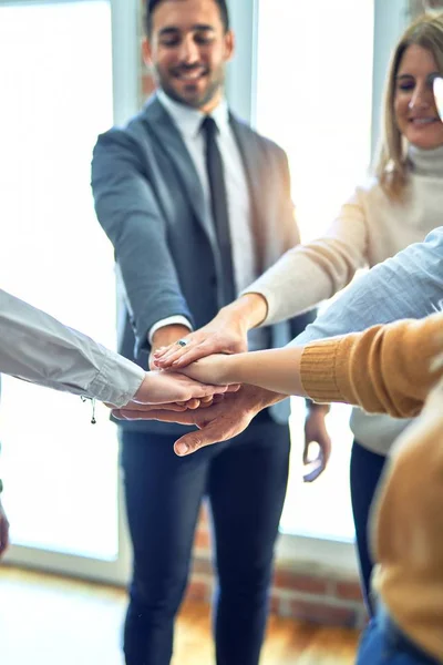 Group of business workers standing with hands together at the office