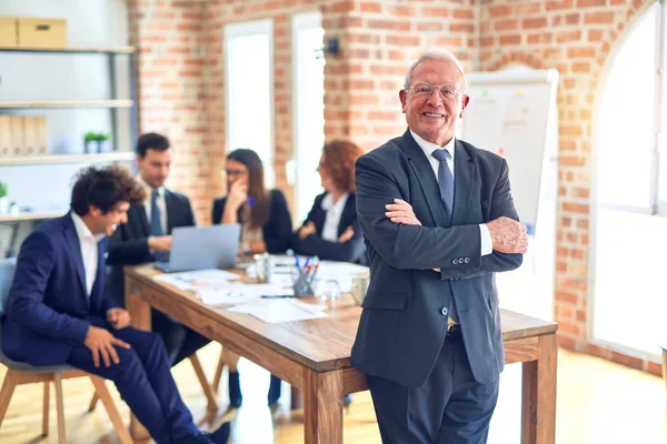 Group of business workers smiling happy and confident working together in a meeting. One of them, standing with smile on face looking at camera at the office.