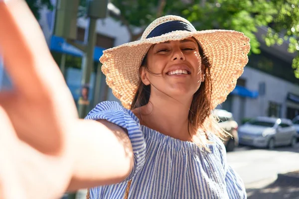 夏の晴れた日に街を歩いて幸せな笑顔の若い女性がスマートフォンを使って自撮り写真を撮る — ストック写真