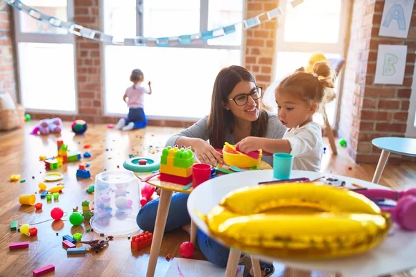 Young Beautiful Teacher Toddlers Playing Table Lots Toys Kindergarten — Stock Photo, Image