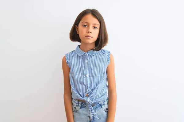 年轻漂亮的小女孩穿着蓝色休闲衫站在孤立的白色背景上 脸上有着严肃的表情 简单而自然地看着相机 — 图库照片