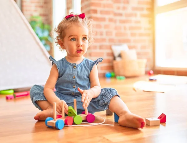 漂亮的高加索婴儿在五颜六色的游戏室玩玩具 幼稚园带木制火车的快乐和玩乐 — 图库照片