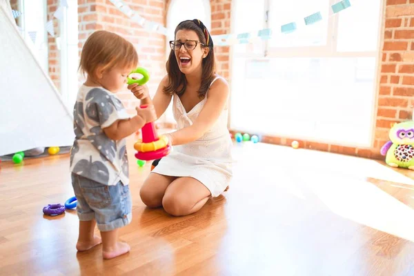 Beautiful Teacher Toddler Building Pyramid Using Hoops Lots Toys Kindergarten — Stock Photo, Image