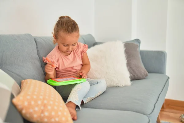 Schöne Blonde Kleinkind Mädchen Sitzt Auf Dem Sofa Zeichnung Mit — Stockfoto
