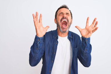 Mavi kot gömlek giyen orta yaşlı yakışıklı adam, izole edilmiş beyaz arka planda ayakta duruyor. Kollarını kaldırmış, gözlerini kapatmış heyecanlı çığlıklar atarak başarının çılgınlığını kutluyor. Kazanan konsept