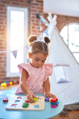 Anaokulunda matematik oyunu oynayan genç ve güzel bir çocuk.