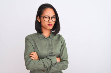 Young chinese woman wearing green shirt and glasses over isolated white background skeptic and nervous, disapproving expression on face with crossed arms. Negative person.