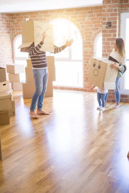 Yeni evde karton bel kutuları ile oynayan çocuk ile güzel famiily