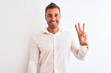 Soyutlanmış arka planda zarif gömlekler giyen yakışıklı bir iş adamı üç numaralı parmaklarıyla gülümseyerek kendinden emin ve mutlu bir şekilde onu işaret ediyor..