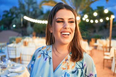 Parti şöleninde mutlu ve neşeli gülümseyen gelinlikli güzel ve zarif bir kadın.