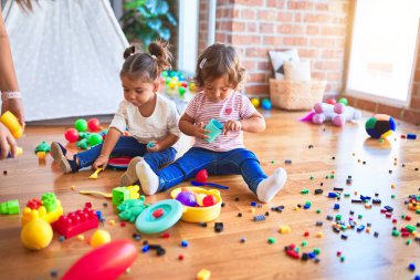 Anaokulunda plastik yemek ve çatal bıçak kullanarak yemek oynayan sevimli bebekler.
