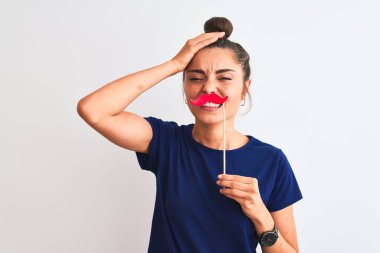 İzole edilmiş beyaz arka planda popo partisi bıyığı tutan genç ve güzel bir kadın. Elleri başının üstünde, utanç ve şaşkınlık dolu, sinirli ve hayal kırıklığına uğramış bir halde. Hata için korku ve üzüntü.