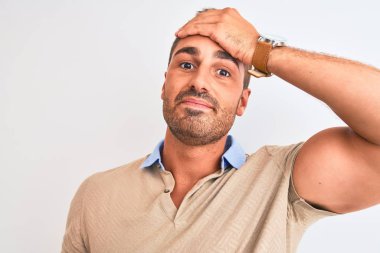 Soyutlanmış arka plan üzerinde zarif bir tişört giyen yakışıklı bir adam. Elleri başının üstünde, utanç ve şaşkınlık dolu, sinirli ve hayal kırıklığına uğramış bir halde. Hata için korku ve üzüntü.