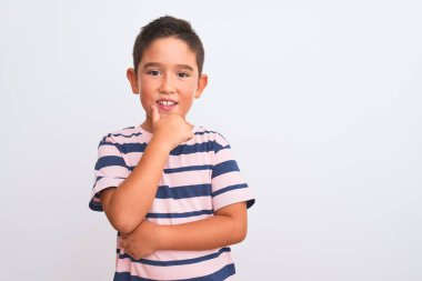 Güzel bir çocuk, izole edilmiş beyaz arka plan üzerinde duran sıradan çizgili tişört giyiyor ve kameraya kollarını kavuşturarak gülümsüyor ve çenesini kaldırıyor. Olumlu düşünüyorum..