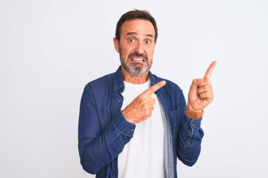 Mavi kot giyen orta yaşlı yakışıklı bir adam izole edilmiş beyaz arka planda dikiliyor. Endişeli ve gergin bir kenara, endişeli ve şaşırmış bir ifade takınıyor.