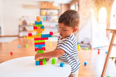 Güzel çocuk anaokulunda inşaat bloklarıyla oynuyor.