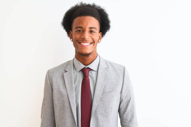 Genç Afro-Amerikan iş adamı takım elbiseli mutlu ve havalı bir gülümsemeyle soyutlanmış beyaz arka planda duruyor. Şanslı kişi..
