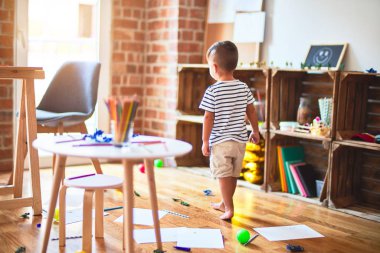 Anaokulunda bir sürü oyuncakla bekleyen güzel bir çocuk.