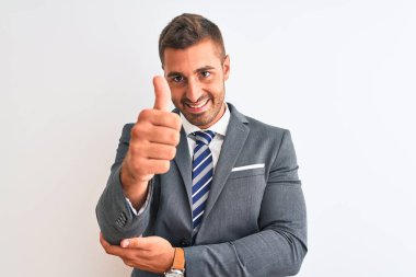 Takım elbiseli ve kravatlı genç bir iş adamı gururlu görünüyor, gülümsüyor yan tarafa baş parmak işareti yapıyor.