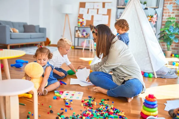 Όμορφη Δασκάλα Και Ομάδα Μικρών Παιδιών Που Παίζουν Γύρω Από — Φωτογραφία Αρχείου