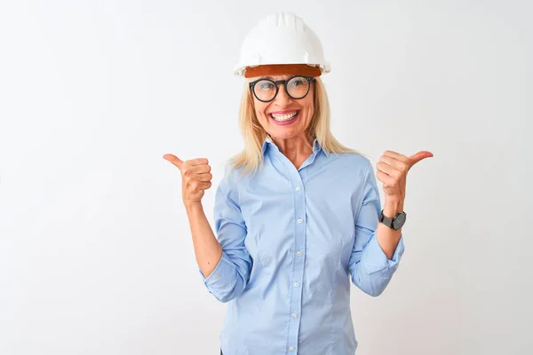 中年建筑师女人戴着眼镜和头盔 戴着孤立的白色背景的成功标志 用手做着积极的手势 竖起大拇指 微笑着 快乐地 快乐的表情和胜利的姿态 — 图库照片