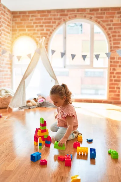 Schöne Blonde Kleinkind Mädchen Spielt Mit Plastikklötzen Einen Turm Kindergarten — Stockfoto