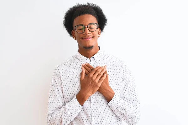 白い背景にエレガントなシャツと眼鏡を身に着けている若いアフリカ系アメリカ人男性は 目を閉じて胸に手で笑顔と顔に感謝のジェスチャー 健康コンセプト — ストック写真