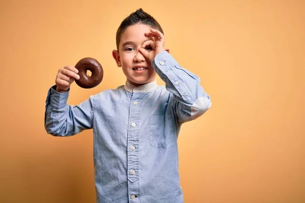 Niño Pequeño Comiendo Donut Chocolate Poco Saludable Sobre Fondo Amarillo — Foto de Stock