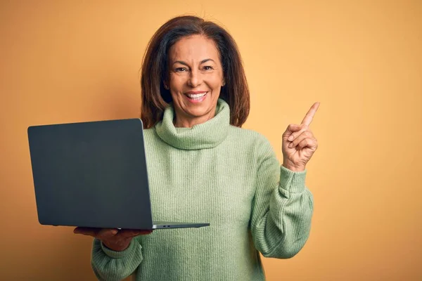 Μέση Ηλικία Μελαχρινή Γυναίκα Χρησιμοποιώντας Φορητό Υπολογιστή Πάνω Από Κίτρινο — Φωτογραφία Αρχείου