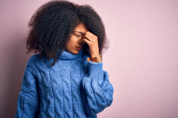 ピンクを背景に冬のセーターを着てアフロの髪を持つ若い美しいアフリカ系アメリカ人女性は 鼻をこすり疲れや目が疲労や頭痛を感じます ストレスとフラストレーションの概念 — ストック写真
