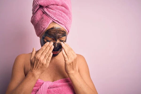 Middle age brunette woman wearing beauty black face mask over isolated pink background rubbing eyes for fatigue and headache, sleepy and tired expression. Vision problem