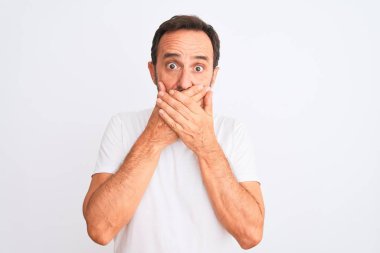 İzole edilmiş beyaz arka planda duran sıradan tişört giyen orta yaşlı yakışıklı bir adam yanlışlıkla ağızlarını kapatarak şok geçirdi. Gizli konsept.