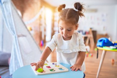 Anaokulunda matematik oyunu oynayan genç ve güzel bir çocuk.